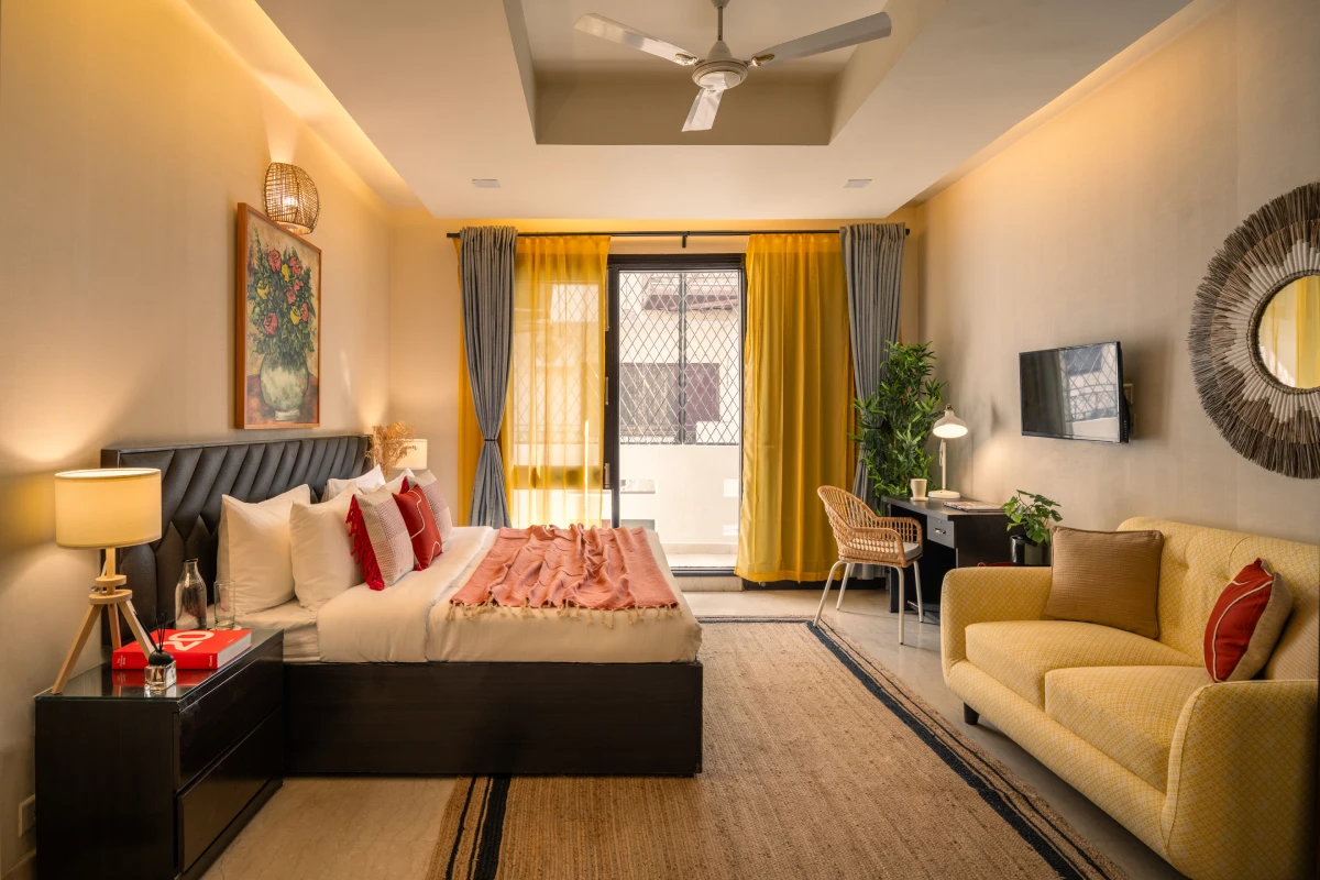 Bedroom with pop of yellow coloured sofa at an apartment in Delhi.